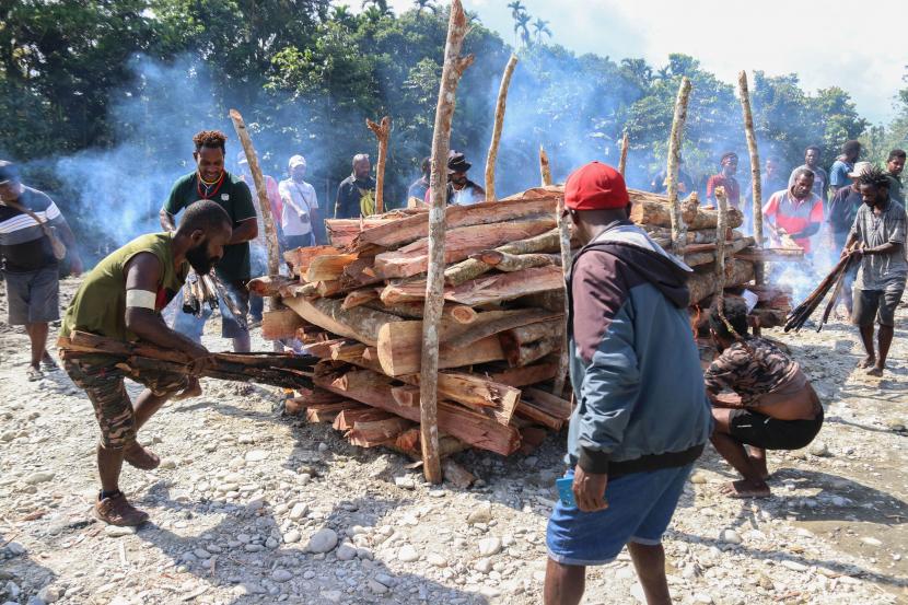 Keluarga menyalakan api saat prosesi kremasi jenazah korban pembunuhan dan mutilasi di Mimika, Papua, Jumat (16/9/2022). Empat korban pembunuhan dan mutilasi dengan tersangka prajurit TNI AD dan warga sipil yang dilatarbelakangi rekayasa pembelian senjata api senilai Rp250 juta tersebut diambil oleh keluarga untuk dikremasi. 
