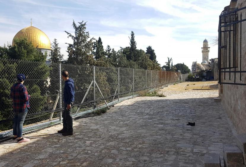 Bagi Keluarga Ini, Tinggal di Sebelah Al-Aqsa adalah Bencana. Keluarga Palestina Mohammed Bashiti dan istrinya, Binar, memandang Dome of Rock di kompleks Masjid Al-Aqsa dari halaman rumah mereka di Kota Tua Yerusalem.