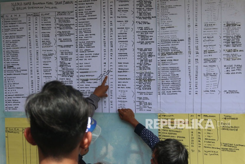 Keluarga penumpang KM Sinar Bangun melihat daftar nama korban yang hilang, di posko Pelabuhan Tigaras, Simalungun, Sumatera Utara, Rabu (20/6). 
