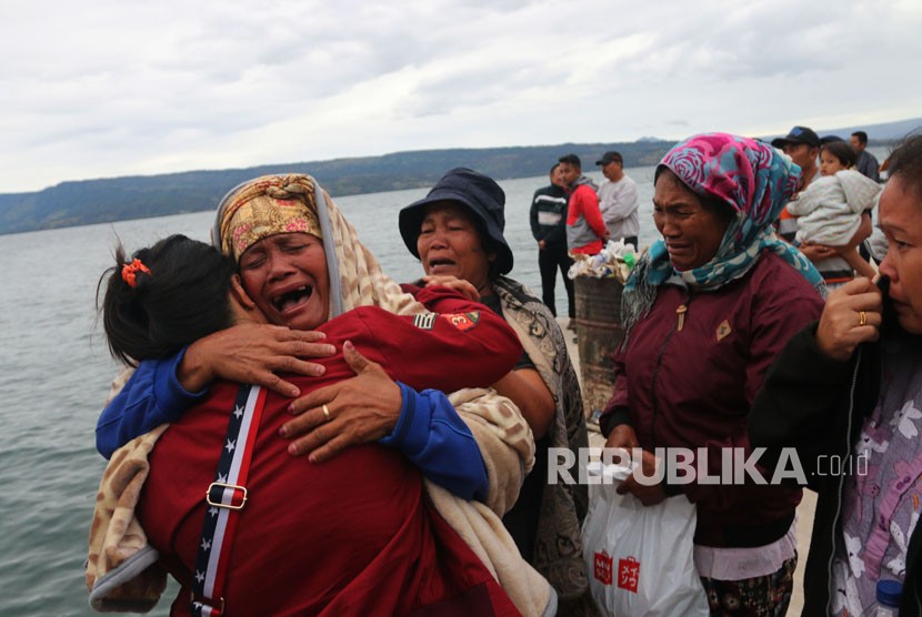 Keluarga penumpang menangis saat menyaksikan proses pencarian penumpang KM Sinar Bangun yang tenggelam di Danau Toba, Simalungun, Sumatra Utara, Selasa (19/6).