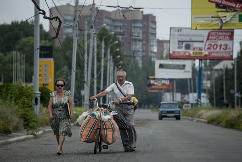 Keluarga Ukraina membawa seluruh miliknya menggunakan sepeda meninggalkan Slovyansk, timur Ukraina.