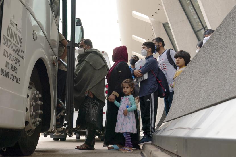 Keluarga yang dievakuasi dari Kabul, Afghanistan, menunggu untuk naik bus setelah mereka tiba di Bandara Internasional Washington Dulles, di Chantilly, Va, pada Kamis, 26 Agustus 2021.