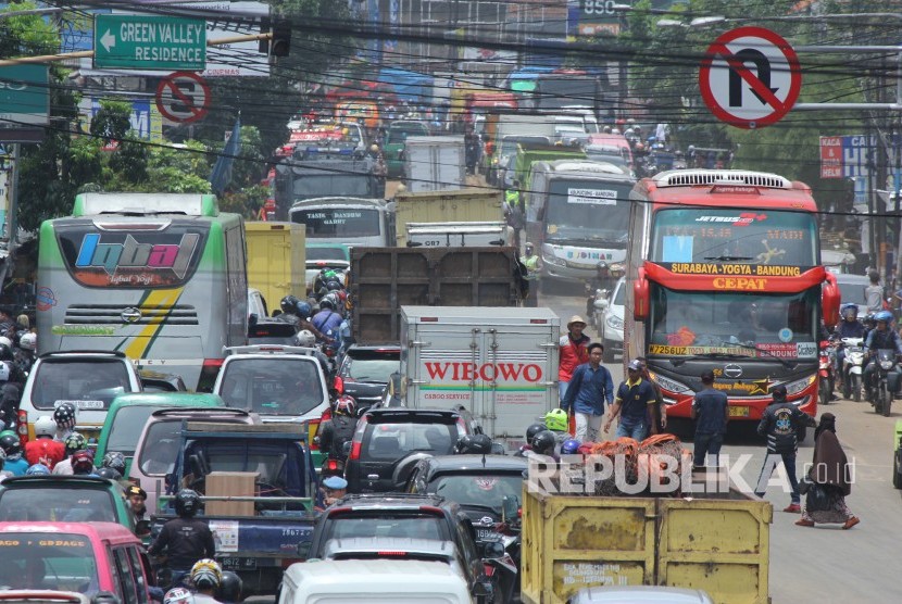 Kemacetan lalu lintas cukup parah saat proses pembersihan jalan yang dipenuhi lumpur dan sampah akibat banjir bandang di Cicaheum, Kota Bandung, Rabu (21/3).