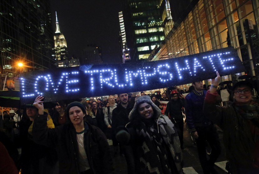 Kemenangan Donald Trump menimbulkan gelombang protes, salah satunya di Manhattan. Warga membawa slogan bertuliskan 'Love Trumps Hate'.