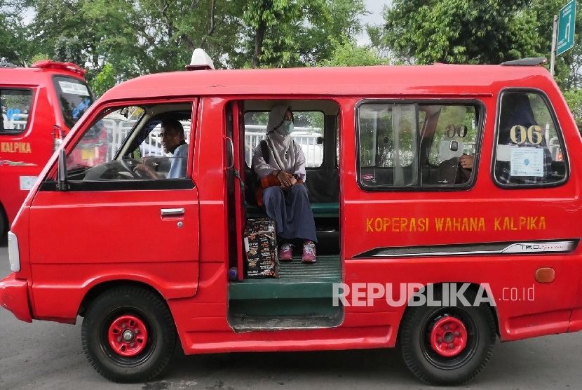 Kendaraan angkutan umum Koperasi Wahana Kalpika (KWK) melintas di kisaran Cililitan Jakarta, Selasa (4/4).