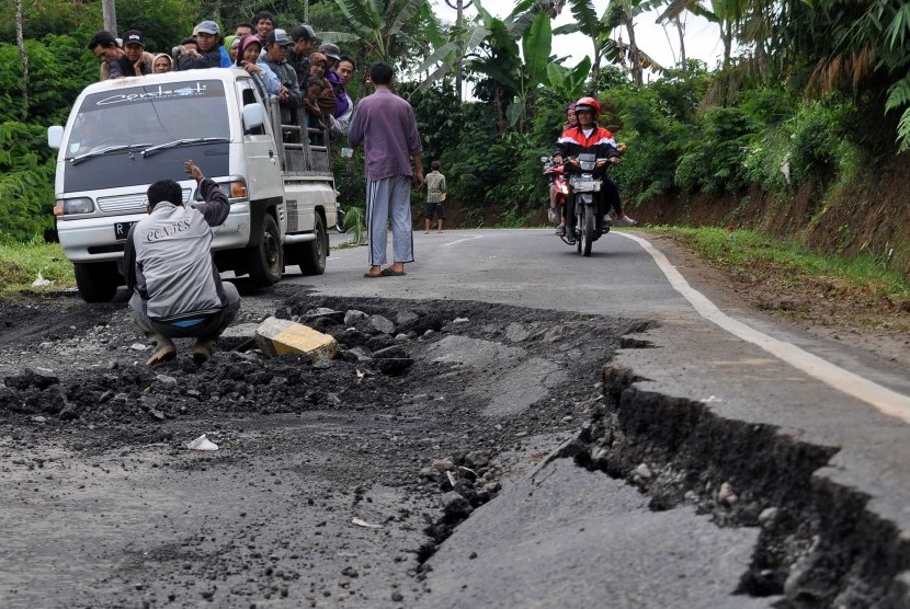 Kendaraan berjalan perlahan saat melintas di jalan raya Banjarnegara-Batur-Wonosobo yang amblas di wilayah Wanayasa, Banjarnegara, Jateng, Sabtu (13/12). Hujan deras beberapa hari terakhir mengakibatkan puluhan titik longsor dan jalan amblas di sepanjang j