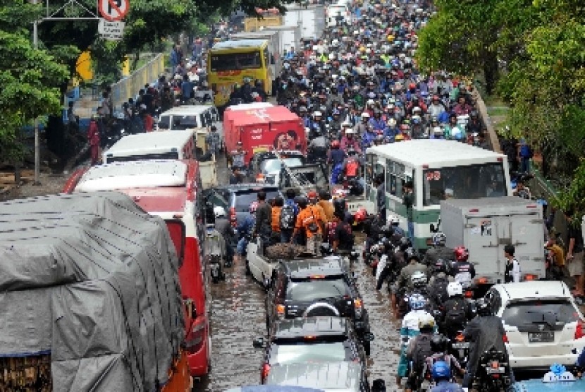 Kendaraan bermotor lawan arah menggunakan lajur kiri untuk menghindari banjir di Jalan Daan Mogot, Jakarta Barat, Selasa (4/2). Kemacetan parah menjadi keseharian di jalan penghubung utama Jakarta-Tangerang setiap banjir. 