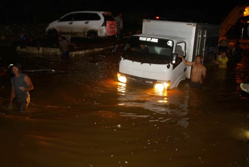 Kendaraan berusaha menerobos banjir yang menggenangi jalan trans Sulawesi penghubung Sulawesi Tenggara-Sulawesi Selatan di Desa Andadowi, Konawe, Sulawesi Tenggara, Selasa (12/6/2019).