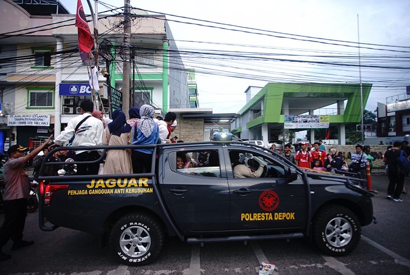 KRL Anjlok. Kendaraan kepolisian Kota Depok mengangkut penumpang yang terlantar di jalan Kartini Pancoran Mas Depok, Jawa Barat, Ahad (10/3/2019). 