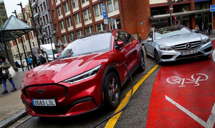 Kendaraan listrik Ford Mustang Mach-e terlihat dicolokkan ke stasiun pengisian daya di Bilbao, Spanyol utara, 10 November 2023. Kendaraan listrik mempercepat berakhirnya era minyak.