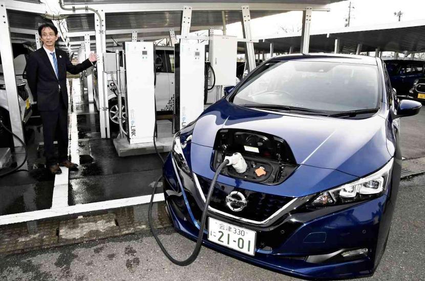 Kendaraan listrik memasok listrik untuk AC di pabrik di Kitakata, Prefektur Fukushima, Jepang.