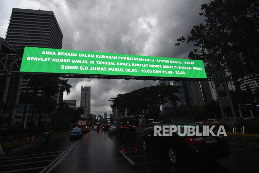 Kendaraan melintas di dekat papan informasi kebijakan sistem pembatasan kendaraan bermotor berdasarkan nomor plat ganjil-genap di kawasan Sudirman, Jakarta, Kamis (21/3/2019).