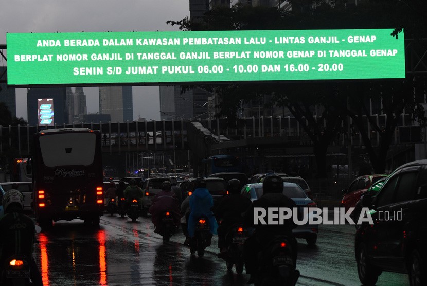 Kendaraan melintas di dekat papan informasi kebijakan sistem pembatasan kendaraan bermotor berdasarkan nomor plat ganjil-genap di kawasan Sudirman, Jakarta, Kamis (21/3/2019). 