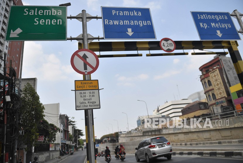 Kendaraan melintas di dekat rambu pembatasan kendaraan ganjil genap yang terpasang di kawasan Matraman di Jakarta, Ahad (8/9/2019). 