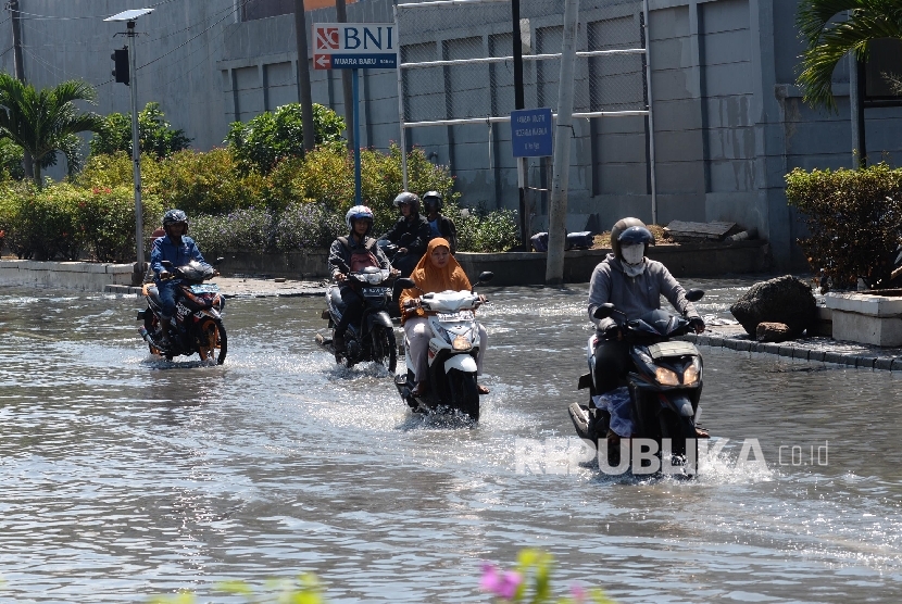   Kendaraan melintas di genangan banjir rob di kawasan pasar ikan Pelabuhan Muara Baru, Penjaringan, Jakarta Utara, Rabu (8/6). (Republika/Yasin Habibi)