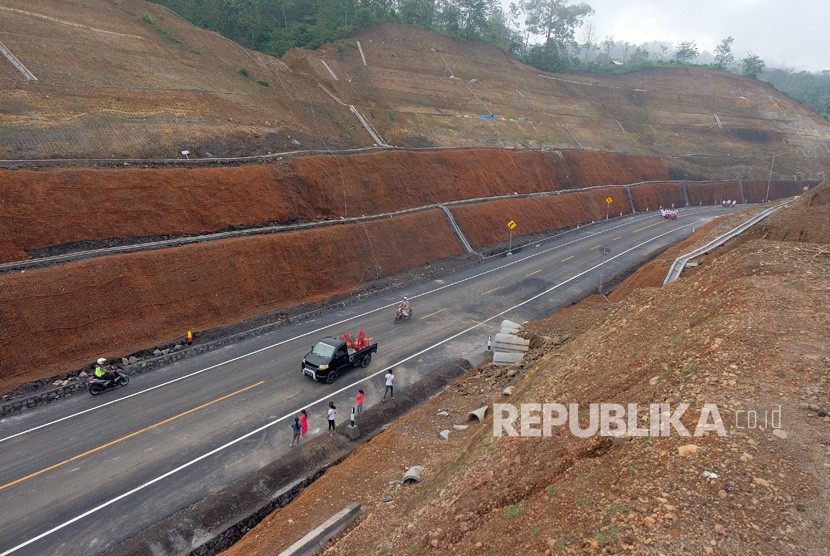 Kendaraan melintas di jalan baru setelah peresmian jalan pintas jalur Singaraja-Mengwitani titik 5 - 6 di Desa Pegayaman, Buleleng, Bali. Jokowi Resmikan Jalan Pintas Singaraja-Mengwitani yang hanya terdapat 16 kelokan.