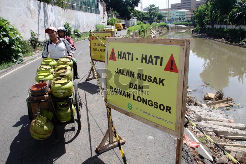  Kendaraan melintas di jalan Inspeksi Ciliwung Lama yang longsor, Jakarta Pusat, Selasa (19/11).  (Republika/Yasin Habibi)