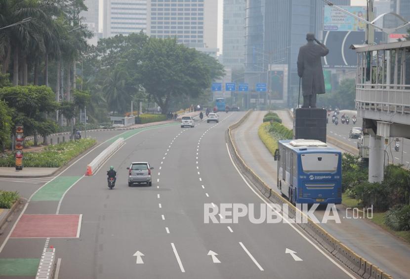 Kendaraan melintas di Jalan Jenderal Sudirman yang terlihat sepi pada hari pertama Idul Fitri 1442 H, Jakarta Selatan, Kamis (13/5/2021).
