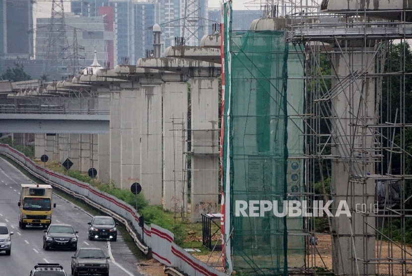 Kendaraan melintas di samping proyek infrastruktur transportasi massal kereta ringan atau Light Rail Transit (LRT) di kawasan Halim, Jakarta. (ilustrasi).