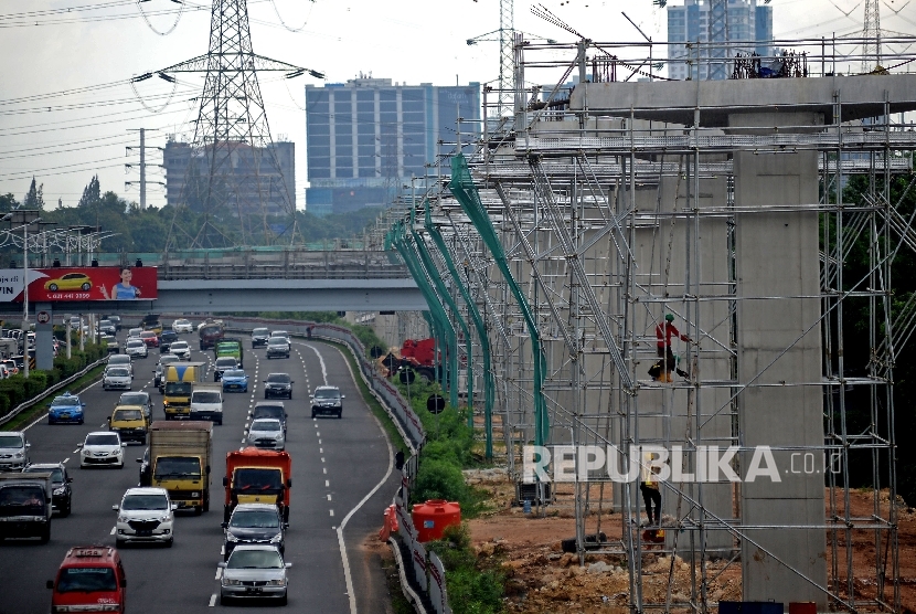 Kendaraan melintas di samping proyek pembangunan tiang penyangga jalur transportasi Light Rail Transit (LRT) rute Cibubur-Cawang di kawasan Halim, Jakarta, Selasa (7/2)