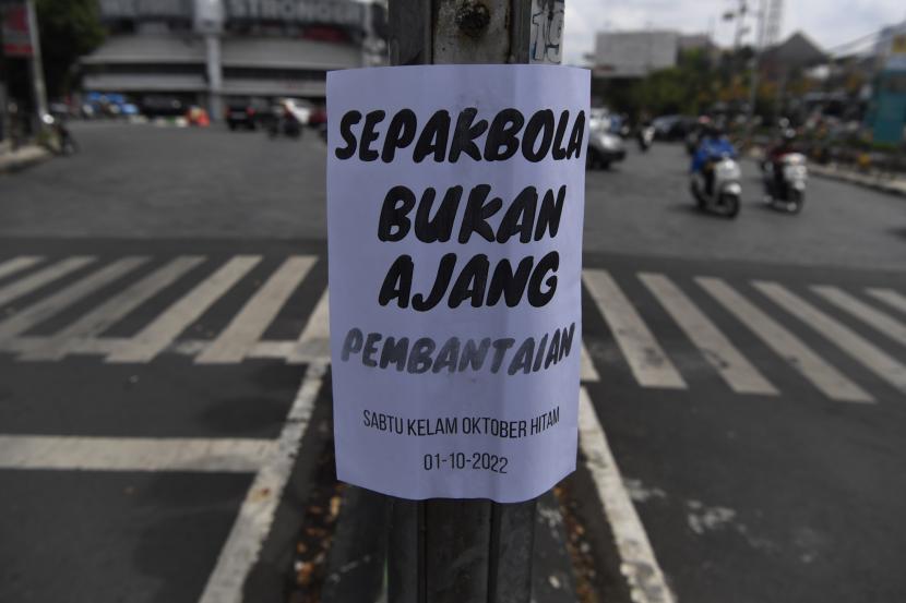Kendaraan melintas di samping selebaran yang tertempel di fasilitas umum, Kota Malang, Jawa Timur, Senin (3/10/2022). Selebaran tersebut berisi kecaman dan tuntutan agar tragedi yang terjadi di Stadion Kanjuruhan segera diusut tuntas.
