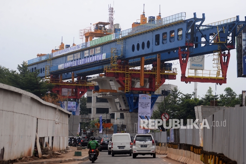 Kendaraan melintas di sekitar proyek kereta ringan atau LRT rute Kelapa Gading- Rawangun yang sudah memulai pemasangan beton box girder, Jakarta, Selasa (30/5).