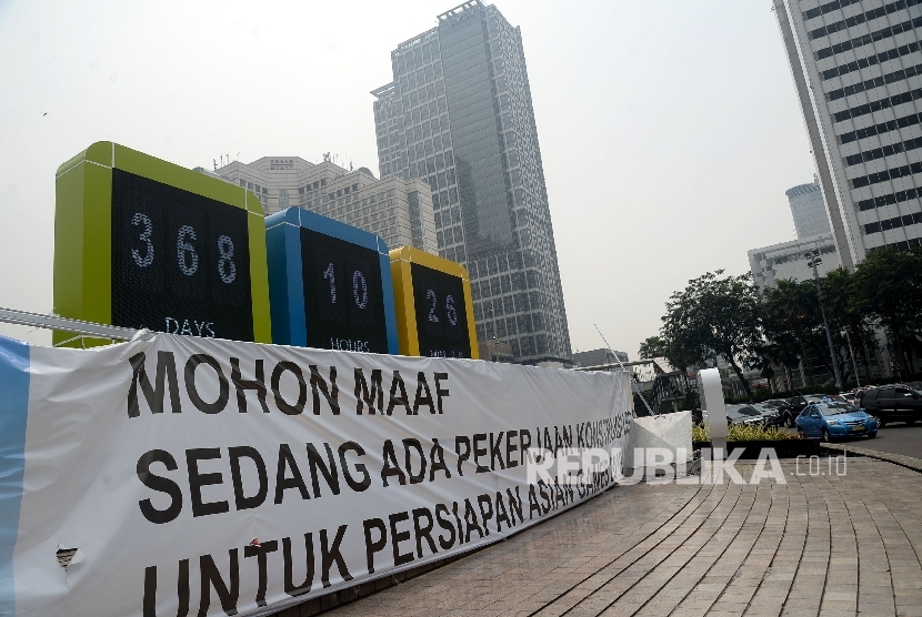  Kendaraan melintas disamping layar digital hitung mundur pelaksanaan Asian Games 2018 di Kawasan Bundaran HI, Jakarta, Senin (14/8). 