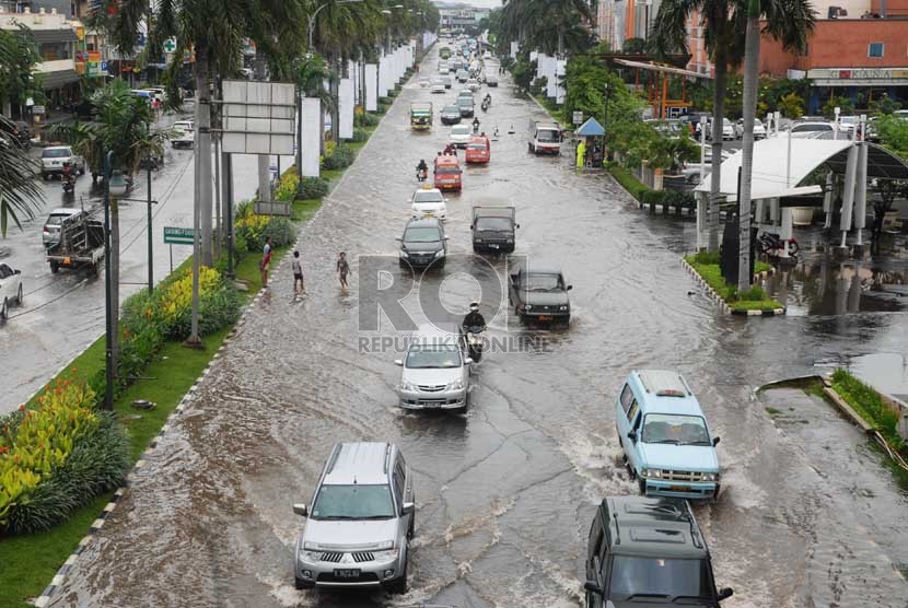  Kendaraan melintasi banjir di Jalan Boulevard Raya, Jakarta Utara, Jumat (17/1). (Republika/Rakhmawaty La'lang)