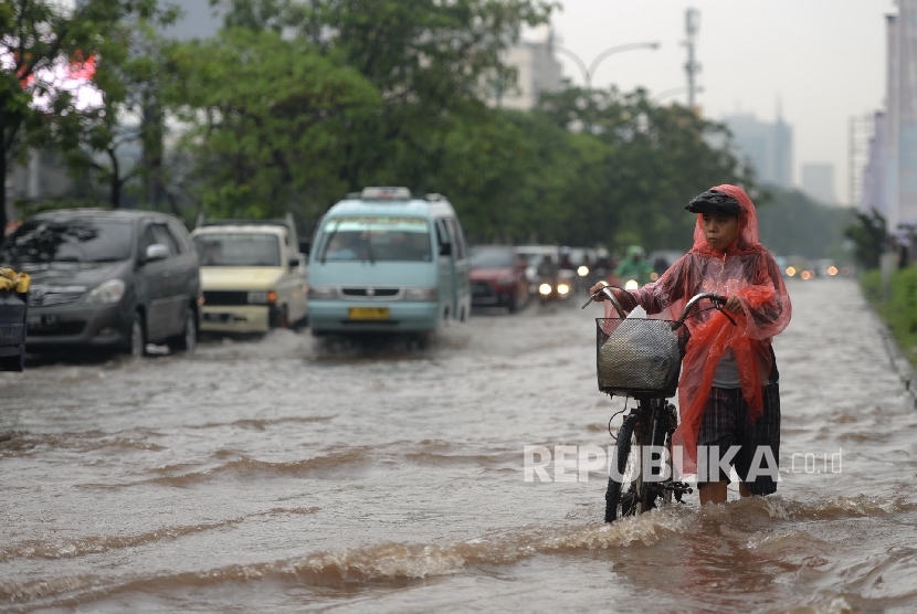 Kendaraan melintasi banjir di Kawasan Kelapa Gading, Jakarta Utara, Jumat (26/2).   (Republika/Wihdan)