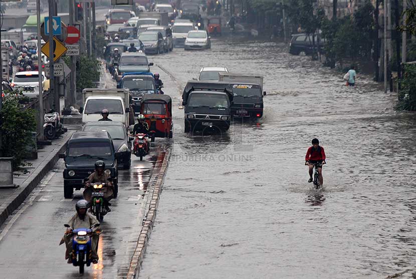 Kendaraan melintasi banjir yang merendam jalan Gunung Sahari, Jakarta Pusat, Kamis (27/2).