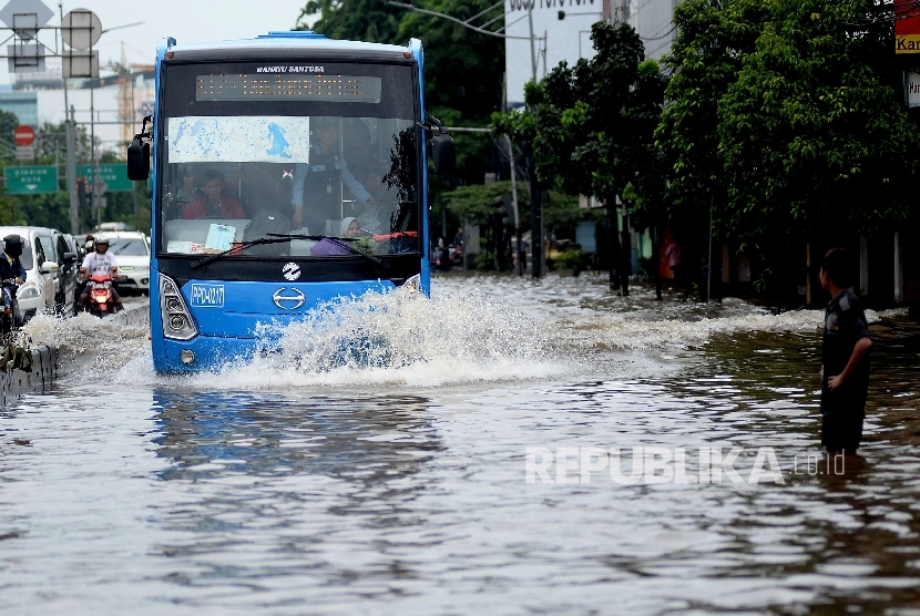  Kendaraan melintasi genangan air di kawasan Gunung Sahari, Jakarta, Selasa (21/2). 