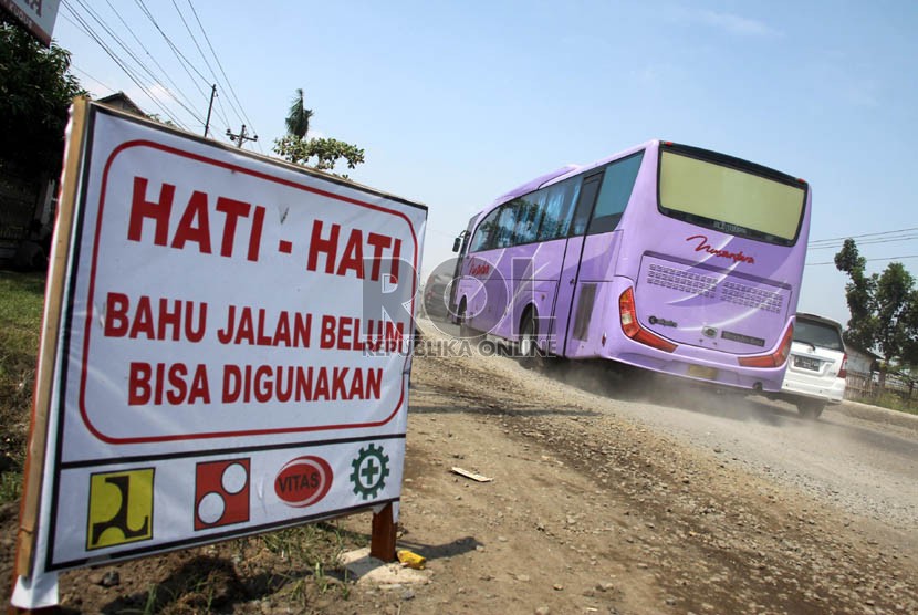  Kendaraan melintasi jalan rusak dan berdebu di jalur pantura, Jalan Raya Comohong, Brebes, Jawa Tengah, Sabtu (3/8).  (Republika/Yasin Habibi)