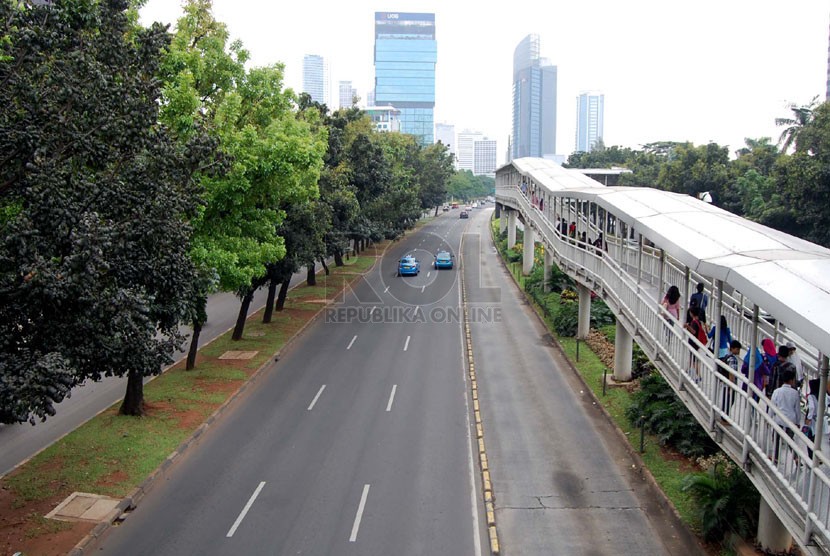   Kendaraan melintasi Jalan Sudirman yang lengang, Jakarta Pusat, Jumat (18/4). (foto : Raisan Al Farisi)