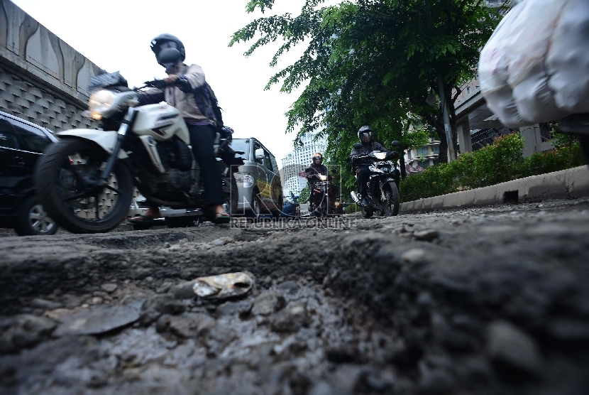 Kendaraan melintasi jalan yang rusak di kawasan Karet, Jakarta Pusat, kamis (12/2).