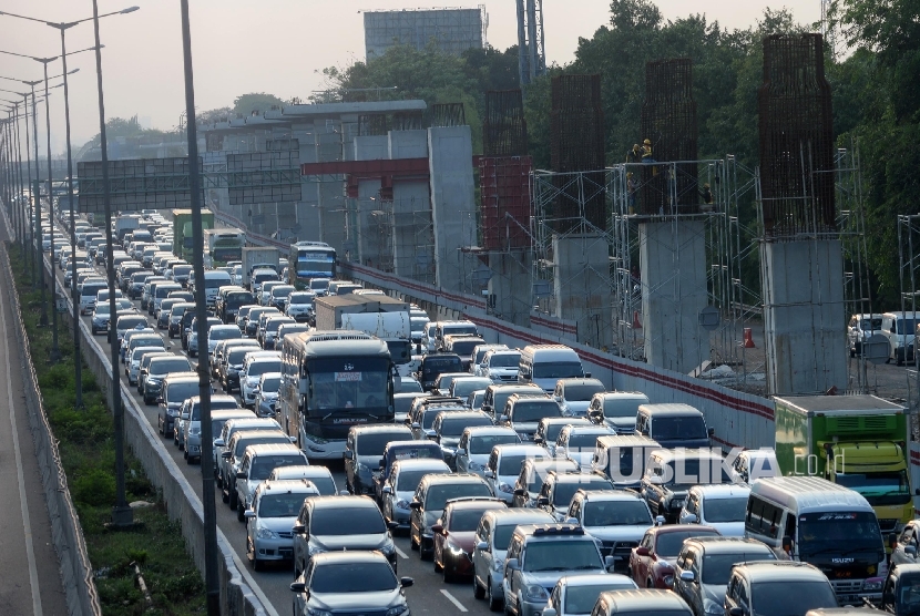 Kendaraan melintasi tol Jakarta-Cikampek disamping pembangunan Light Rail Transit (LRT) di kawasan Jatibening, Bekasi, Jabar, Ahad (8/10).