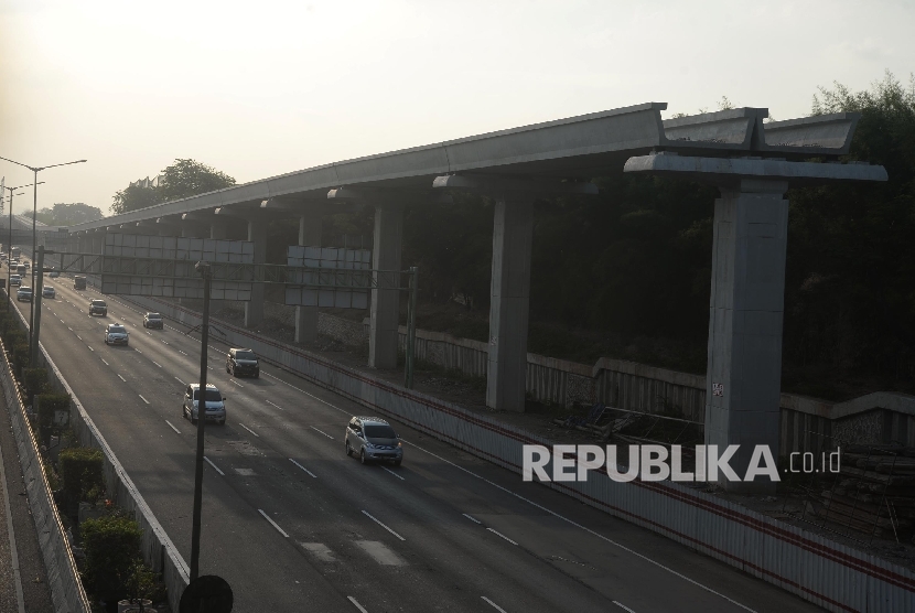 Kendaraan melintasi tol Jakarta-Cikampek disamping pembangunan Light Rail Transit (LRT) di kawasan Jatibening, Bekasi, Jabar, Ahad (8/10). 