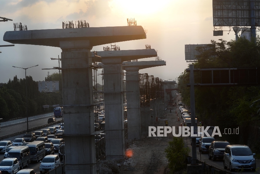 Kendaraan melintasi tol Jakarta-Cikampek disamping pembangunan Light Rail Transit (LRT) di kawasan Jatibening, Bekasi, Jabar, Ahad (8/10).