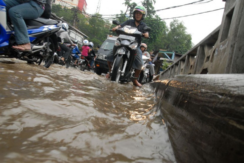 Kendaraan menerobos genangan air yang berasal dari Kali Baru di kawasan Condet, Cililitan, Jakarta Timur, Senin (10/8).