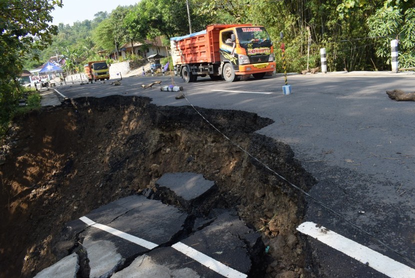 Kendaraan menghindari jalan yang ambles dan longsor di Sawoo, Ponorogo, Jawa Timur, Selasa (25/4). 