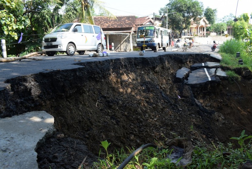 Kendaraan menghindari jalan yang ambles dan longsor (ilustrasi)