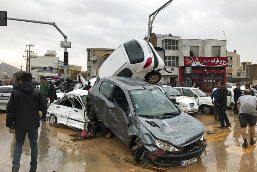 Kendaraan menumpuk di jalan akibat banjir bandang di Shiraz, Iran, Senin (25/3).