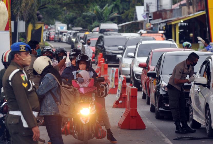Kendaraan roda empat antre memasuki kota saat masa PSBB, di Posko Perbatasan Kayukalek, Padang, Sumatera Barat, Selasa (26/5). (ilustrasi)