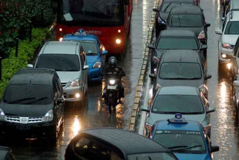 Kendaraan terjebak kemacetan ketika hujan deras mengguyur kawasan Jalan Thamrin, Jakarta, Jumat (21/12). 