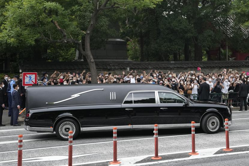 Kendaraan yang membawa jenazah mantan Perdana Menteri Jepang Shinzo Abe meninggalkan kuil Zojoji setelah pemakamannya di Tokyo pada Selasa, 12 Juli 2022. Abe dibunuh Jumat saat berkampanye di Nara, Jepang barat. 