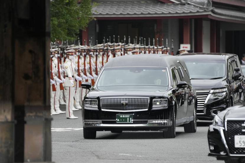  Kendaraan yang membawa jenazah mantan Perdana Menteri Jepang Shinzo Abe meninggalkan kuil Zojoji setelah pemakamannya di Tokyo pada Selasa, 12 Juli 2022. Abe dibunuh Jumat saat berkampanye di Nara, Jepang barat. 