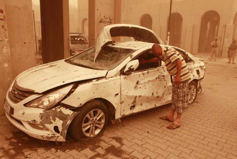 Kendaraan yang rusak akibat terkena ledakan bom mobil di jalan Haifa, Bagdad, Kamis (19/4).