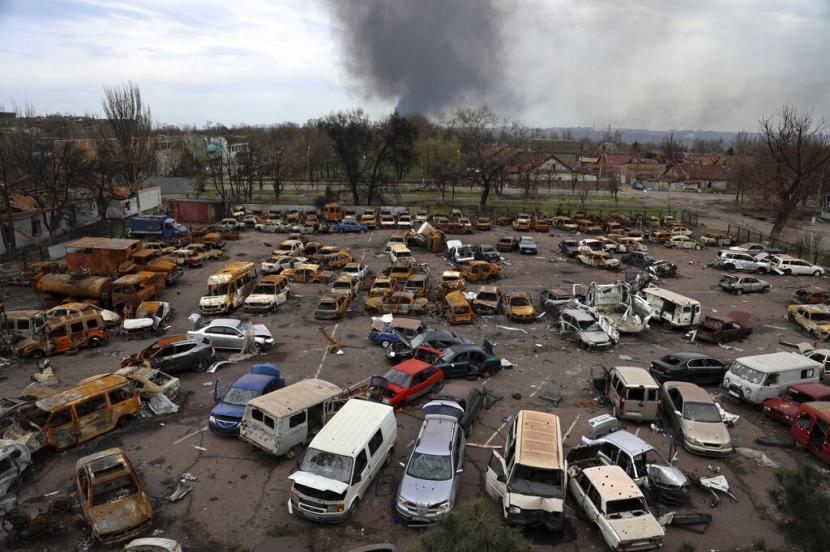Kendaraan yang rusak dan terbakar terlihat di bagian yang hancur dari Pabrik Metalurgi Illich Iron & Steel Works, saat asap mengepul dari Metallurgical Combine Azovstal selama pertempuran sengit, di daerah yang dikendalikan oleh pasukan separatis yang didukung Rusia di Mariupol, Ukraina, Senin, April 18, 2022. Militer Ukraina mengatakan pertempuran di jalan-jalan Kota Kreminna mulai pecah dan proses evakuasi tidak mungkin dilakukan.