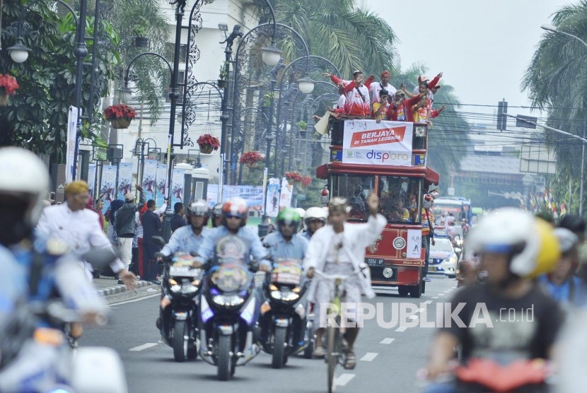 Kendraan Bandros berisi panitia dan para atlet Kota Bandung saat Kirab Api PON XIX 2016 di Jl Asia Afrika, Kota Bandung, Jumat (16/9). (Mahmud Muhyidin)