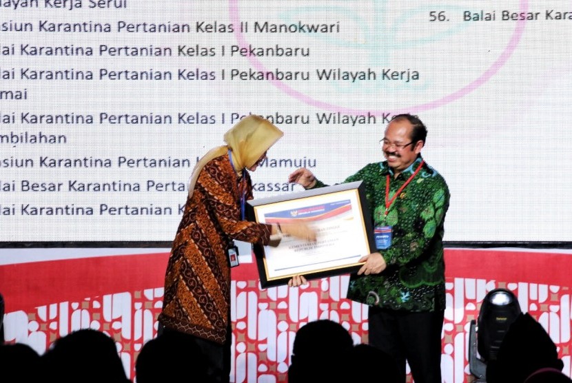 Kepala Badan Karantina Pertanian Kementerian Pertanian Banun Harpini (kiri) saat menerima penghargaan dari Ombudsman RI di Hotel Borobudur, Jakarta, Rabu (7/12).
