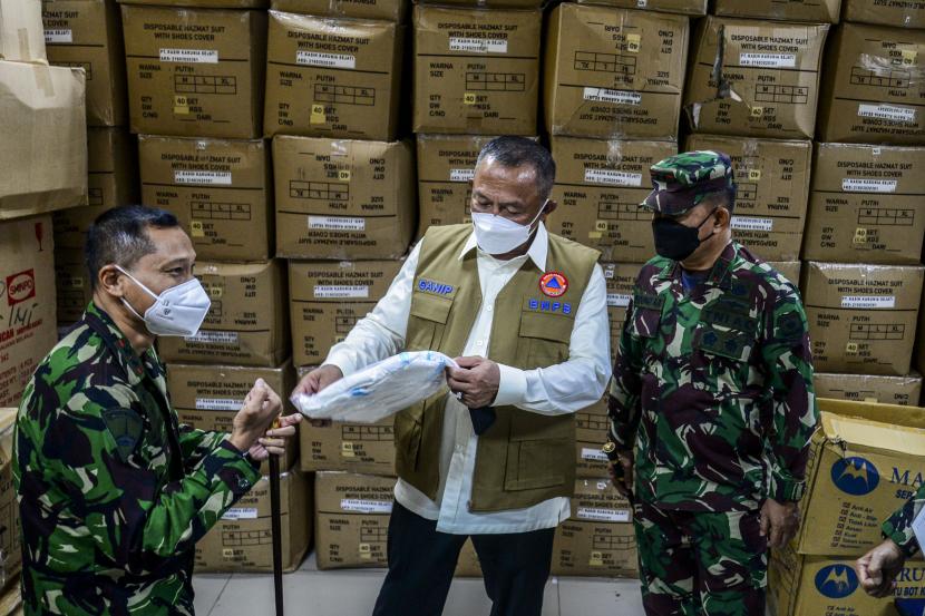 Kepala Badan Nasional Penanggulangan Bencana (BNPB) Letjen TNI Ganip Warsito (tengah) bersama Pangdam Jaya Mayjen TNI Dudung Abdurachman (kanan) dan Komandan Lapangan Rumah Sakit Darurat Covid-19 (RSDC) Wisma Atlet Letkol (Mar) Muhammad Arifin (kiri) melihat baju hazmat saat mengunjungi RSDC Wisma Atlet, Kemayoran, Jakarta.